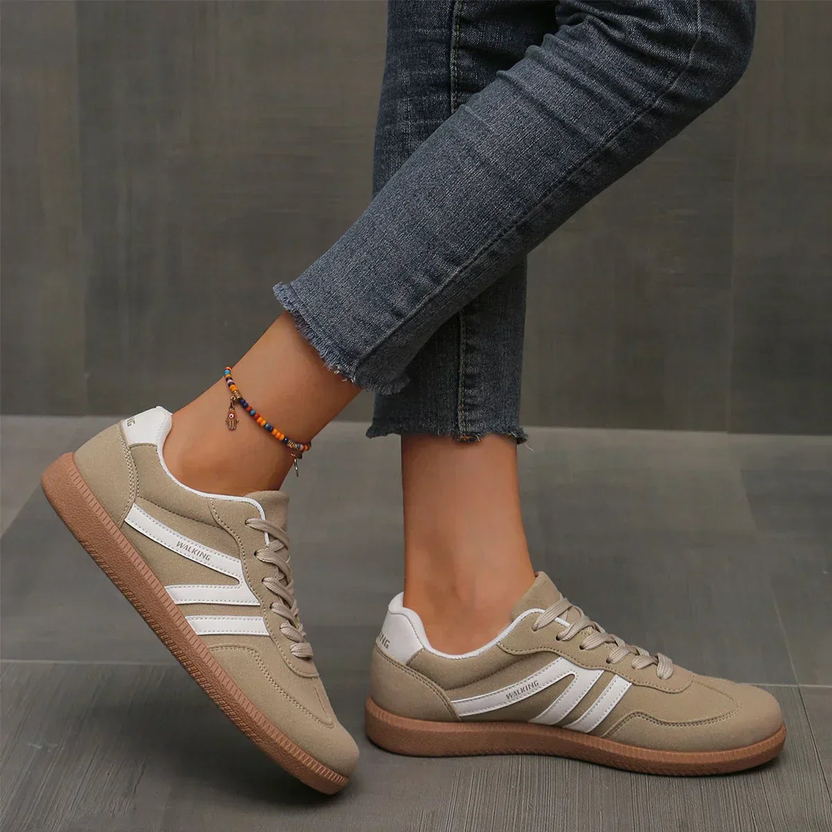 "Women's modern low-top lace-up sneakers with chic side stripes, perfect for casual attire and sporty wear."