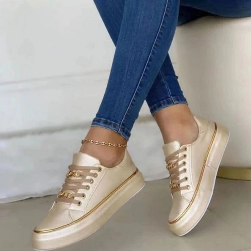 Women's platform sneakers with bold gold chain, round toe, and lace-up closure; stylish design suitable for all seasons.
