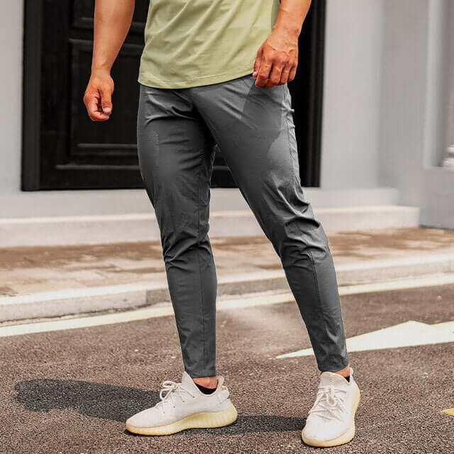Close-up of men's tapered joggers showing zipped pockets