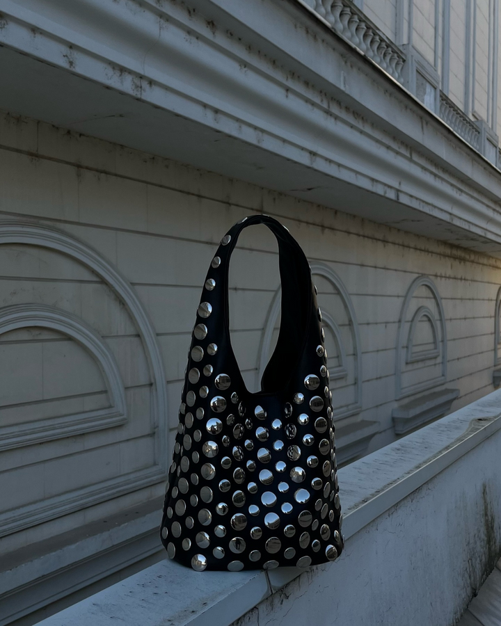 Stylish women's black rivet shoulder bag, a studded faux leather fashion accessory for making a statement, ideal for evenings.