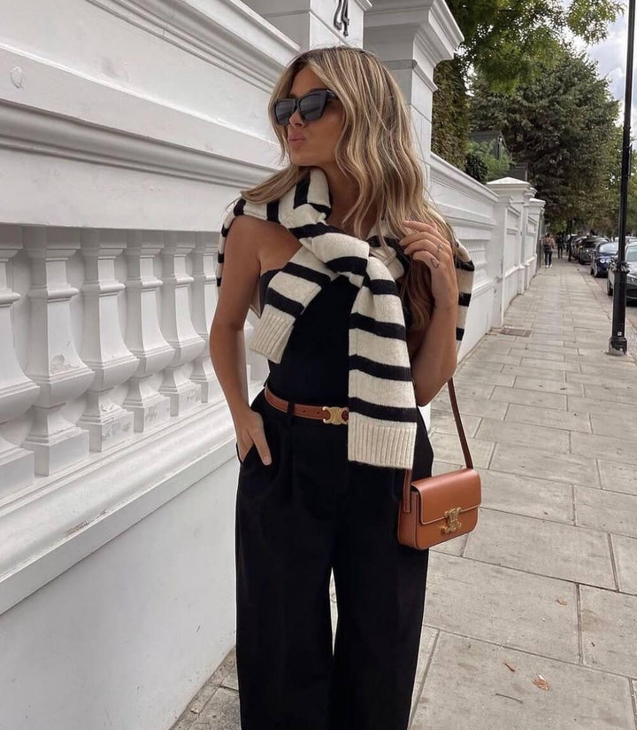 Black leather women's belt with a gold buckle, elegant and versatile for both casual and formal outfits, shown in detail.