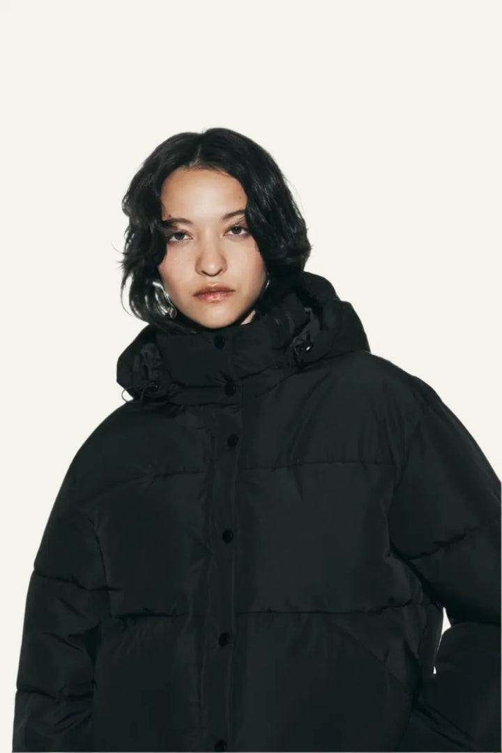 Sleek black women's puffer jacket. Modern design, warm and comfortable for daily winter fashion.