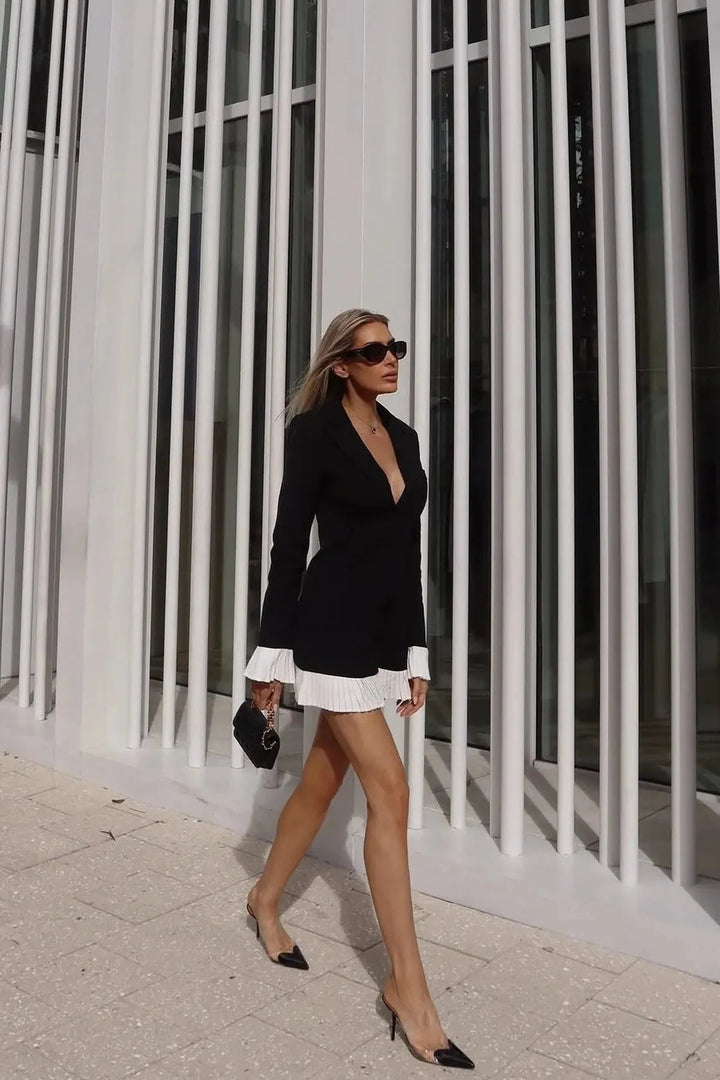 Chic women's black mini dress, featuring a flattering V-neck, tailored pleats, and stylish button front details.