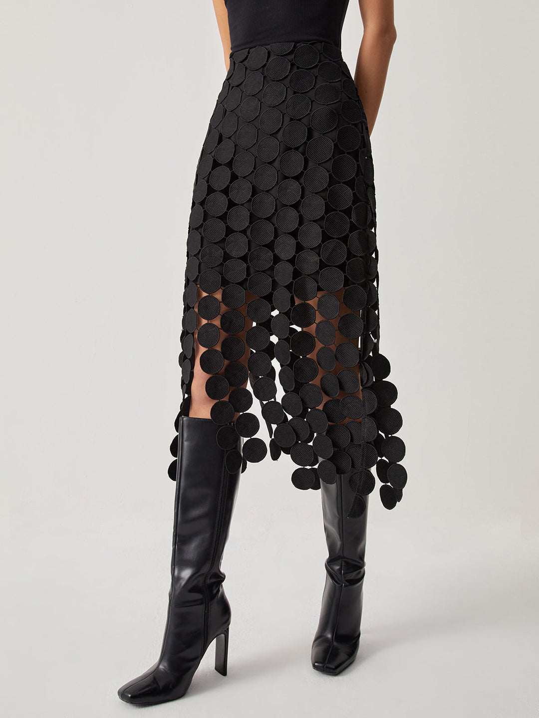 Black women's laser cut midi skirt, elegant with unique circle pattern. High-waisted, perfect for a fashion statement.