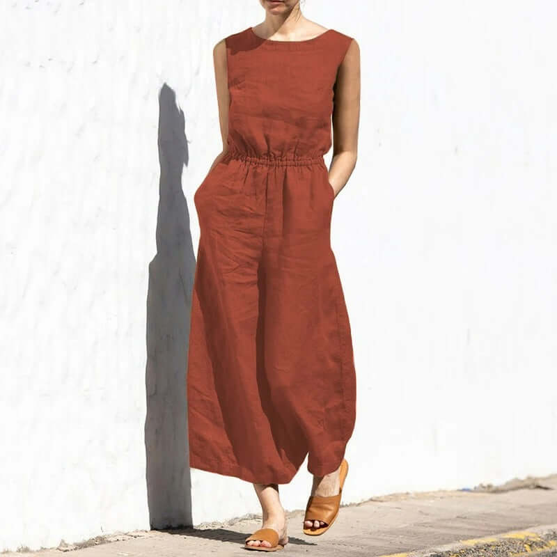 Sleeveless women's jumpsuit in a neutral color, worn casually.