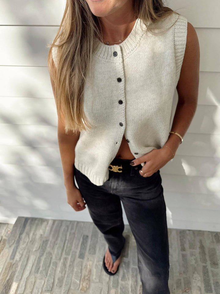 Women's button-front sweater vest in a stylish apricot knit, designed for versatile layering and chic looks.