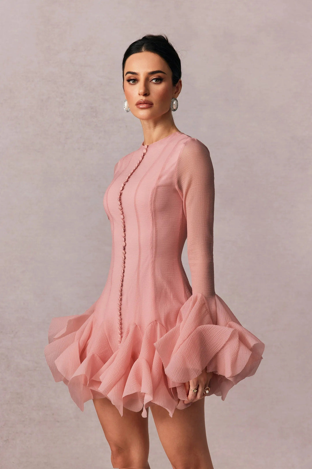 Fashionable pink ruffled mini dress with long sleeves for women. A chic choice for any party or event.