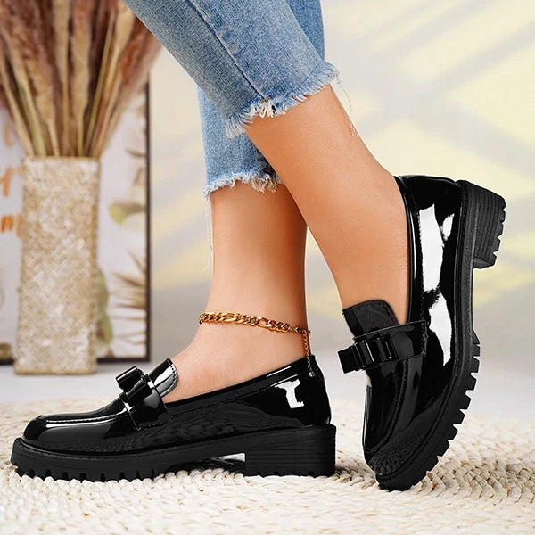 Elegant bow detail on women's black platform loafers, ideal slip-on shoes for dressy or casual wear.