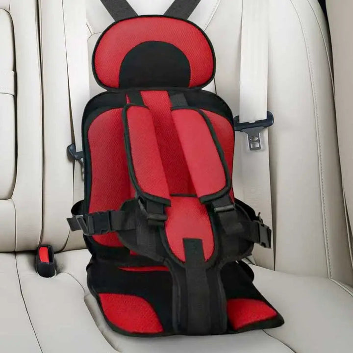 Child car cushion seat in red for ages 0-12, showcasing soft, compact design and secure restraints for safe, comfortable trav
