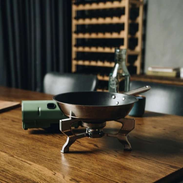 Compact windproof camping gas stove with foldable design, perfect for outdoor use; fits easily into backpacks for adventure.