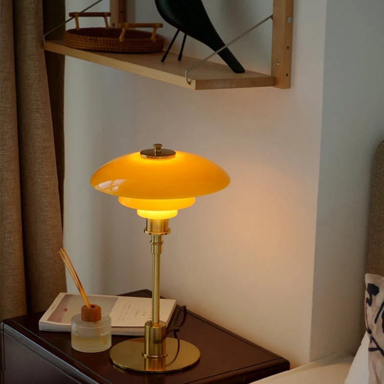 Contemporary Danish designer table lamp with warm LED light, sleek Scandinavian form, amber finish, and premium glass.