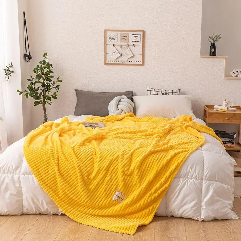 Soft flannel throw blanket accenting a bed, providing warm, cozy comfort for bedroom decor. Thick autumn essential.