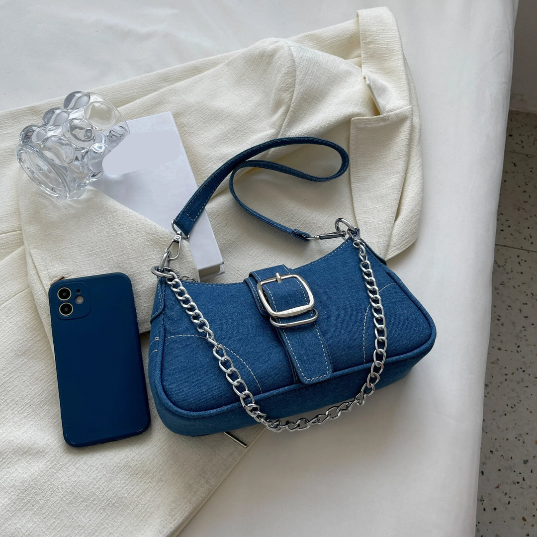Close-up of dark blue women's buckle shoulder bag, showcasing stylish details & versatile design.