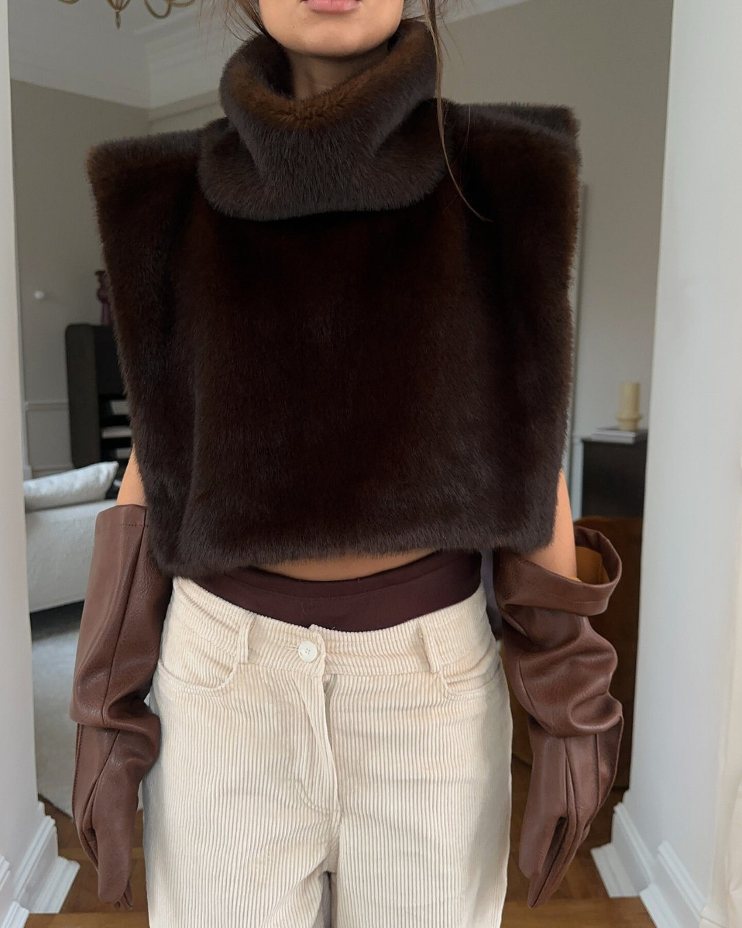 Women's dark brown faux fur vest with a chic turtleneck, offering luxury style and warmth.