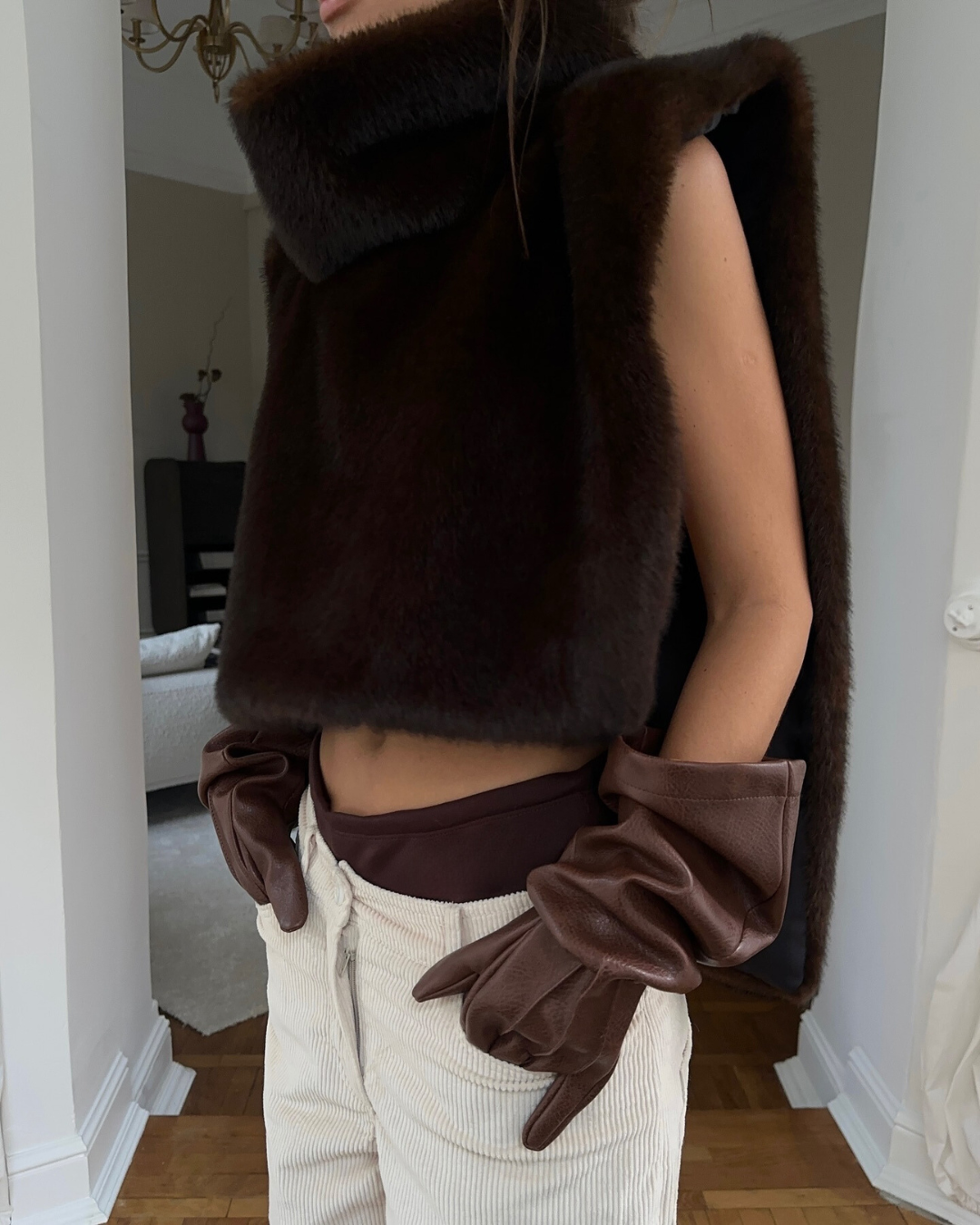 Sleeveless women's faux fur turtleneck vest in dark brown, a luxurious winter fashion piece.
