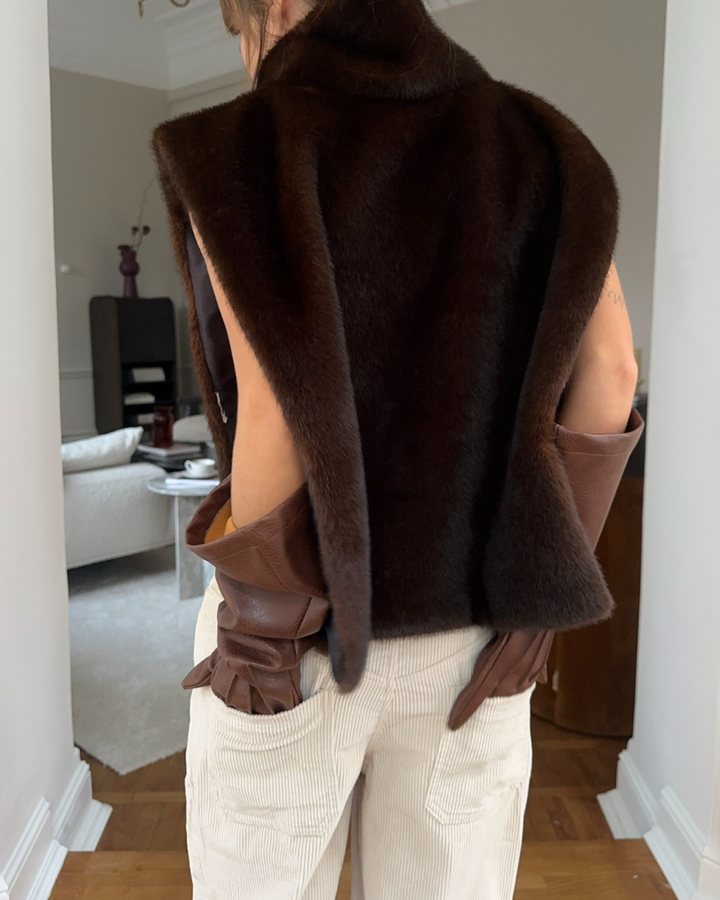 Stylish women's faux fur vest with turtleneck for elegant winter layering, in rich dark brown.