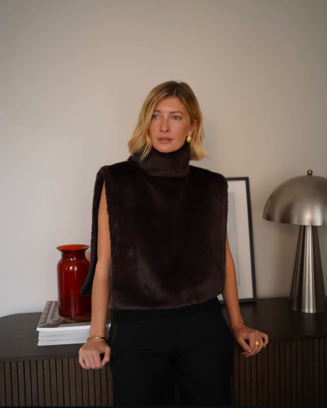 Women's soft dark brown faux fur vest, featuring a warm turtleneck, ideal for winter luxury.