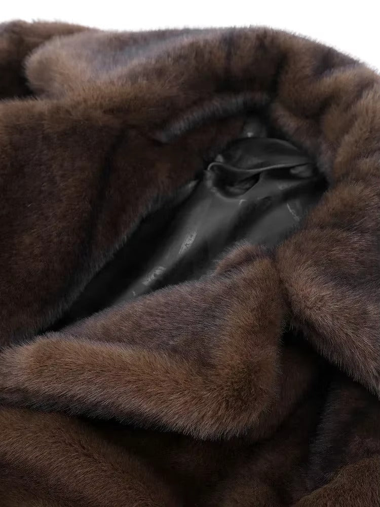 Cozy dark brown long plush winter coat for women. Elegant outerwear providing warmth and chic style.