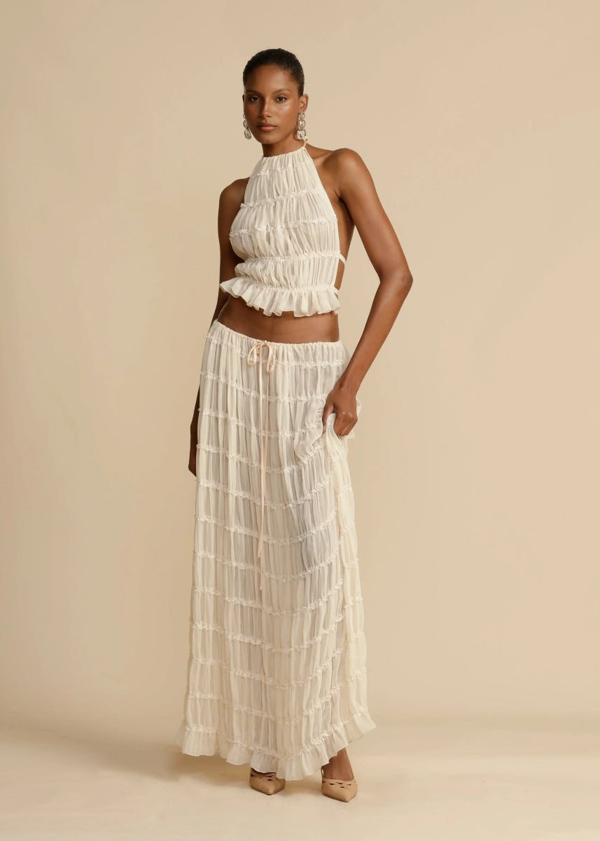 Black women's two-piece summer maxi skirt set with halter top, chic vacation or beach outfit.