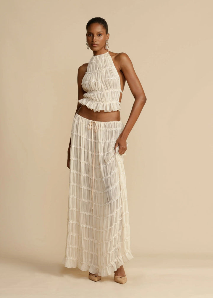 Black women's two-piece summer maxi skirt set with halter top, chic vacation or beach outfit.
