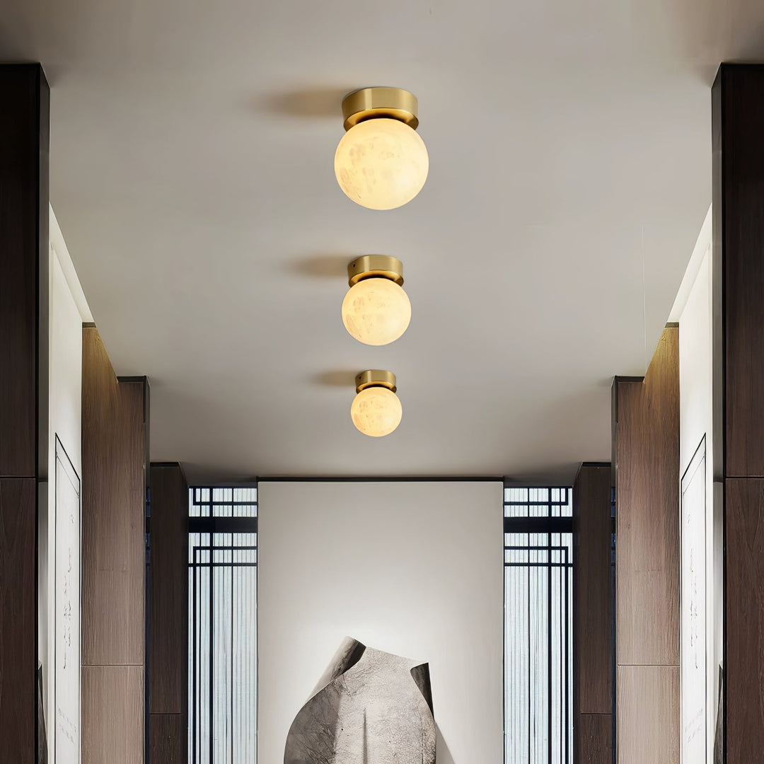 Elegant alabaster brass ceiling lamp, warm ambient light, celestial glow, sophisticated brass detailing, modern design.