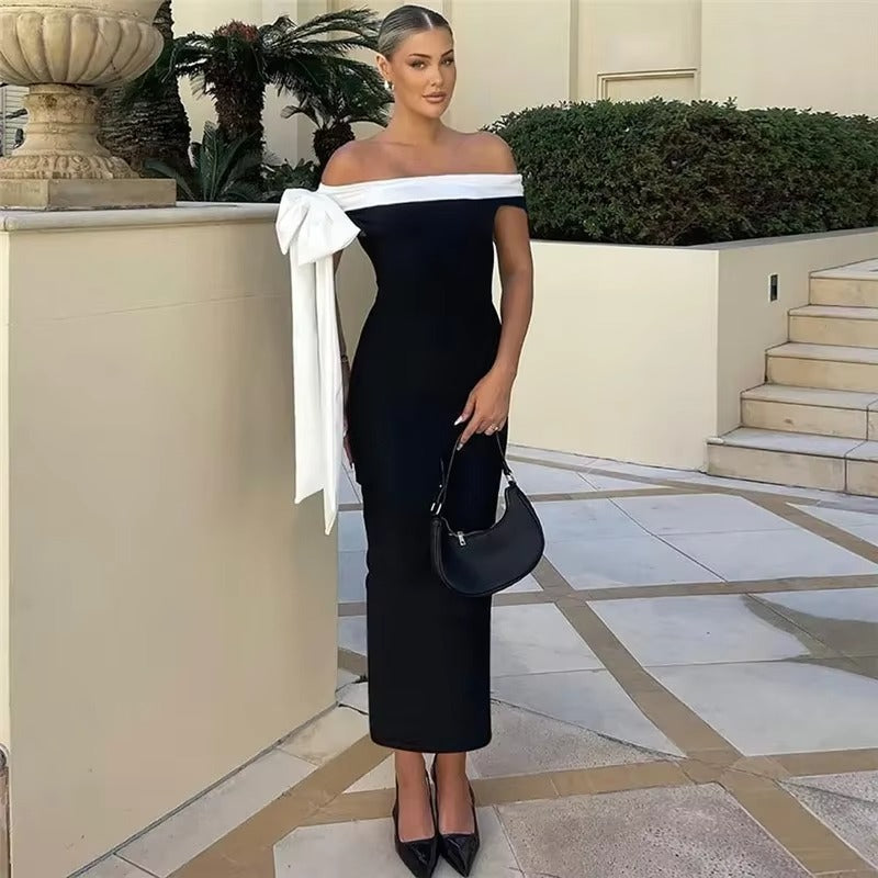 Women's elegant black off-shoulder midi dress with a decorative bow. Ideal for sophisticated evening wear.