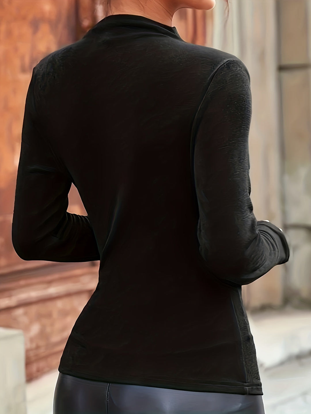 Chic women's fitted mock neck ruched long sleeve top in black, offering an elegant and versatile fashion statement.