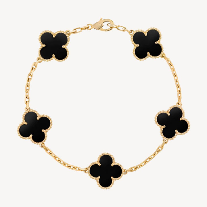 Elegant clover charm bracelet with polished black agate inlays and a gold and silver-tone chain for sophisticated style.