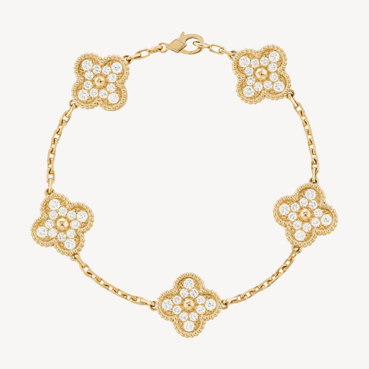 Elegant clover charm bracelet with polished black agate inlays and a gold and silver-tone chain for sophisticated style.