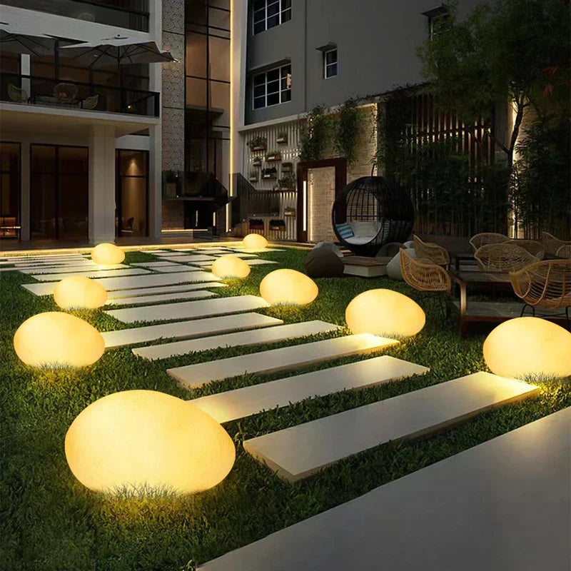 Elegant LED garden light with cobblestone design, glowing in multiple colors, ideal for illuminating outdoor spaces like gard