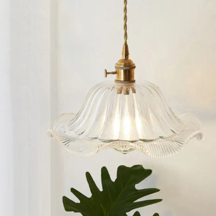 Stylish glass hanging lamp for dining area, creating a warm, elegant glow.