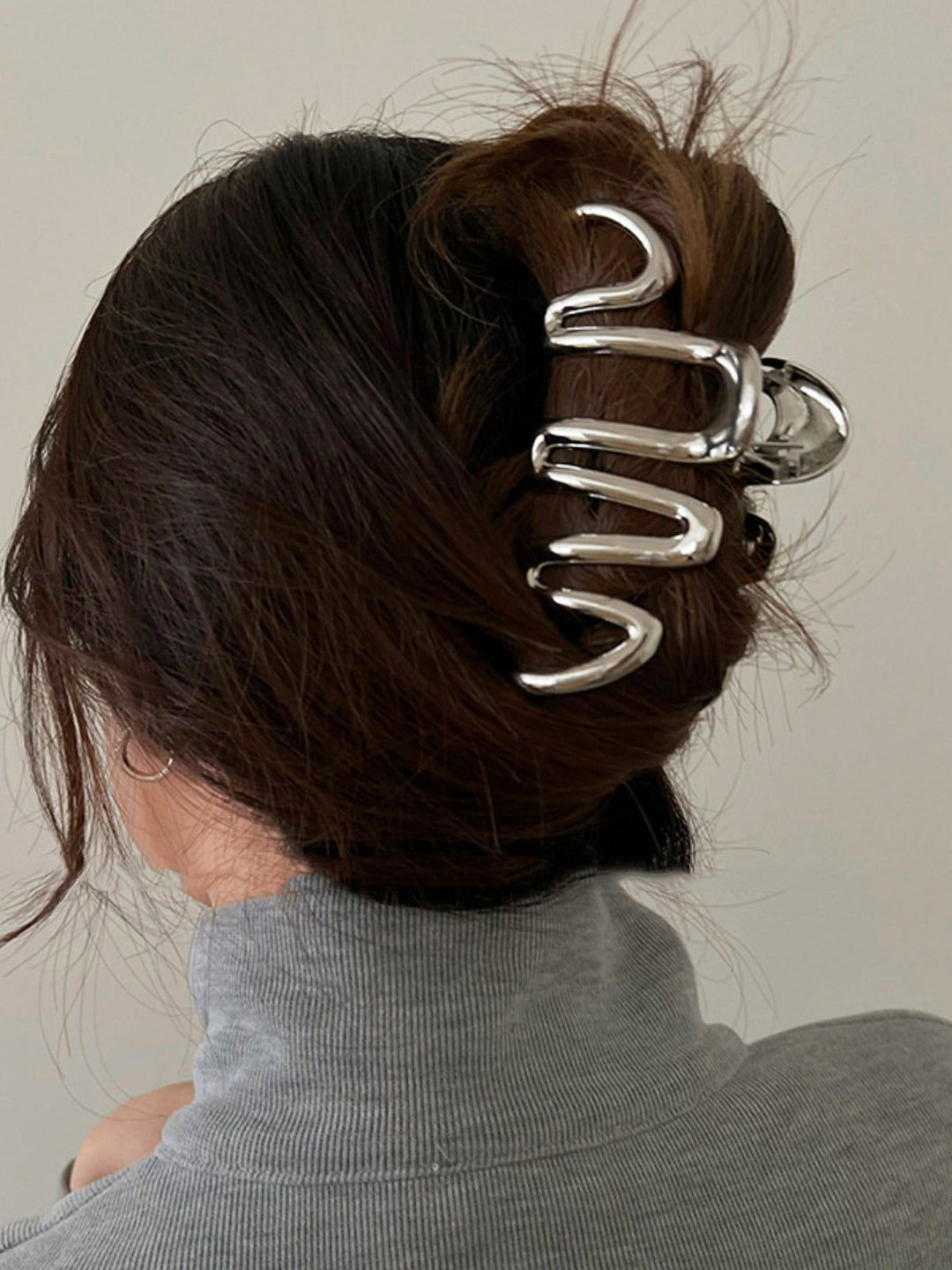 Elegant silver sculptural wave hair claw clip, perfect for women's updos and hair styling accessories.