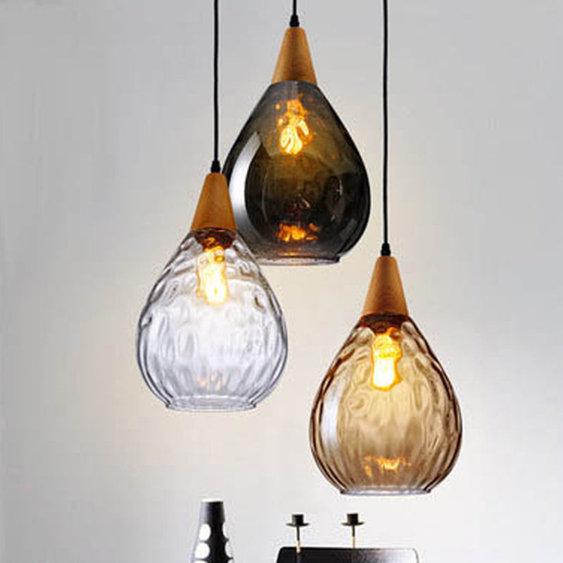 "Elegant teardrop glass pendant light with wood accents, available in clear, golden, smoky gray, perfect for any home decor."