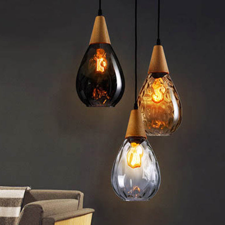 "Elegant teardrop glass pendant light with wood accents, available in clear, golden, smoky gray, perfect for any home decor."