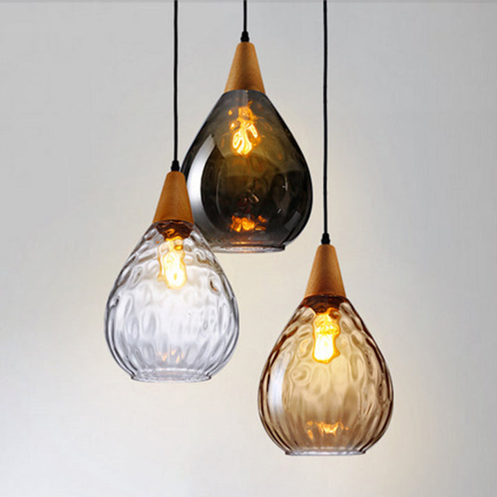 "Elegant teardrop glass pendant light with wood accents, available in clear, golden, smoky gray, perfect for any home decor."