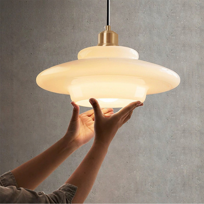 Elegant white glass pendant light with brass fixture, mid-century design, perfect for modern or classic interiors, adds luxur
