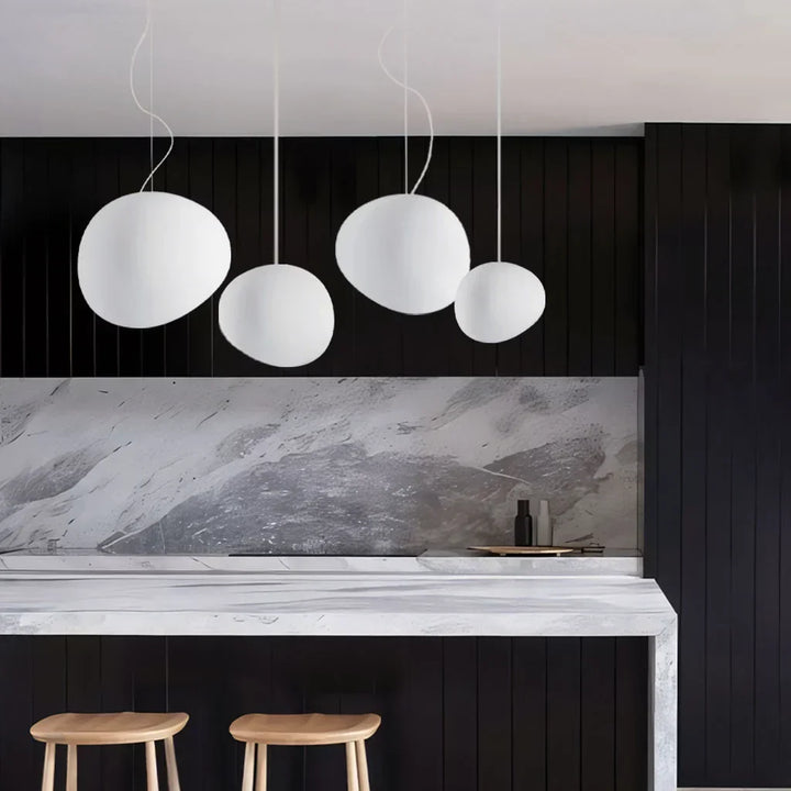 Elegant white pebble pendant light; minimal design, frosted glass, metal accents, soft glow for modern interiors.