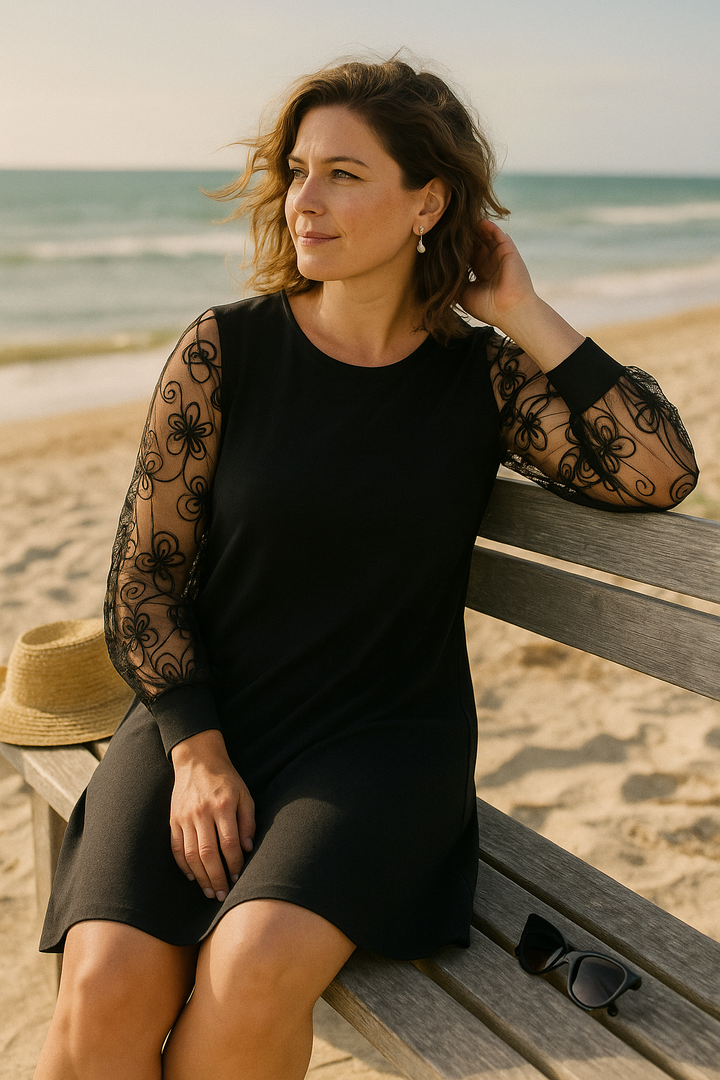 Detailed shot of the intricate embroidery on the sheer long sleeves of a women's elegant A-line formal dress.