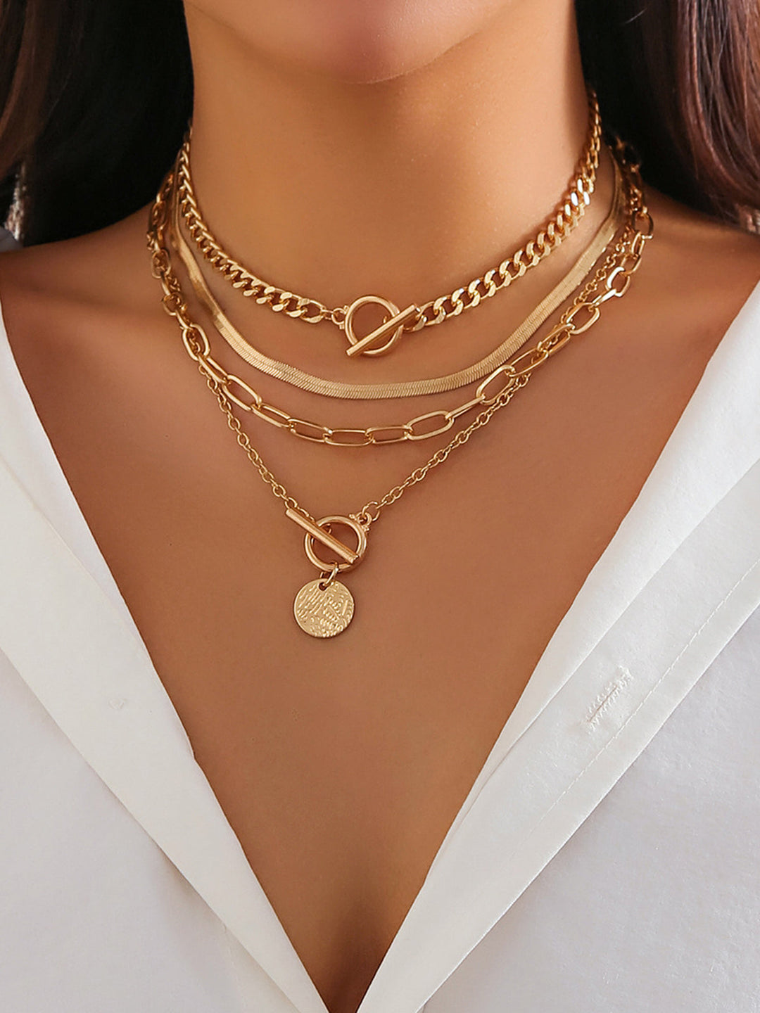 Fashionable women's gold layered necklace set, includes a delicate coin pendant. Versatile jewelry accessory.