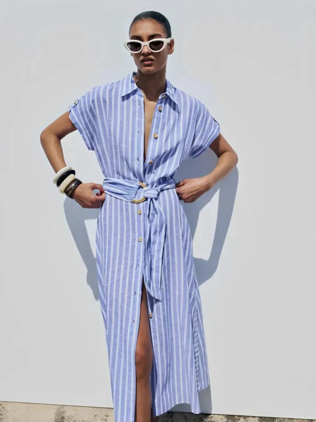 Women's stylish button-down maxi dress in light blue stripes with a flattering self-tie belt. 