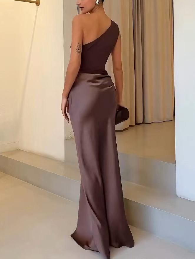 Close-up of the elegant pleats & one-shoulder detail on a women's party maxi dress. Perfect formal attire.