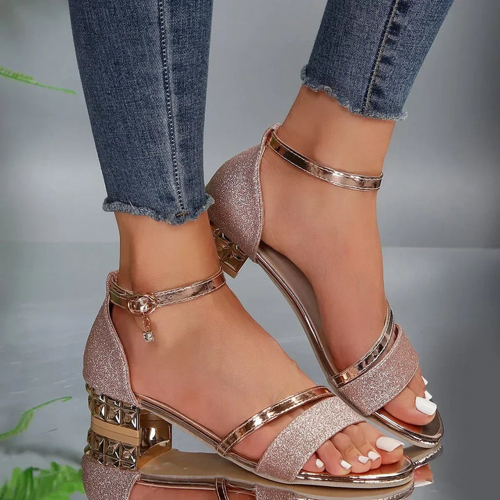 Close-up of the shimmering straps on elegant women's sandals with a supportive block heel and arch support.