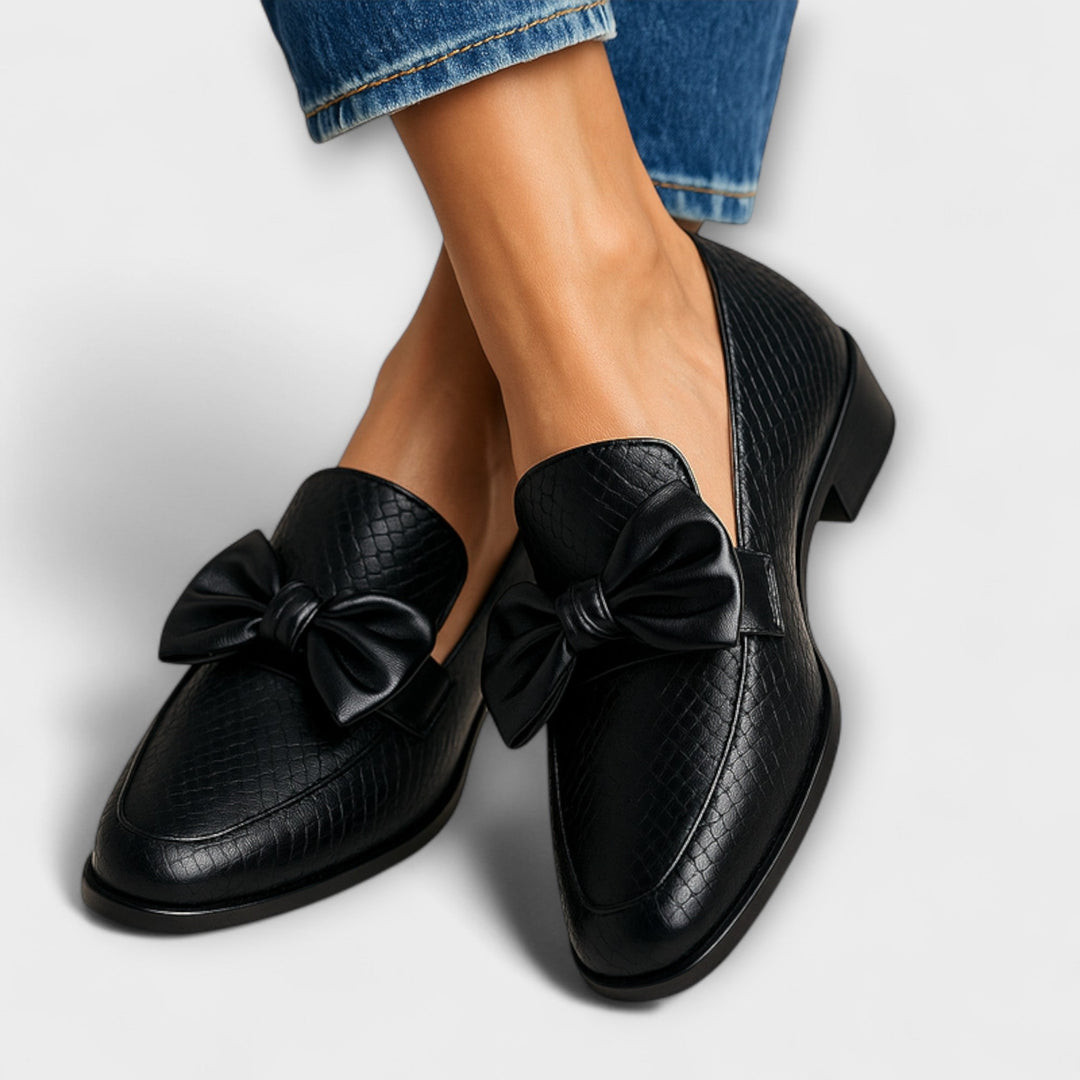 Elegant women's slip-on loafers with a stylish bow detail. Comfortable flats perfect for casual or dress wear.
