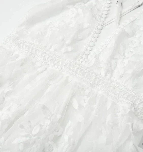 Sleeveless white halter mini cocktail dress with V-neck, elegant floral embroidery, perfect for summer events.