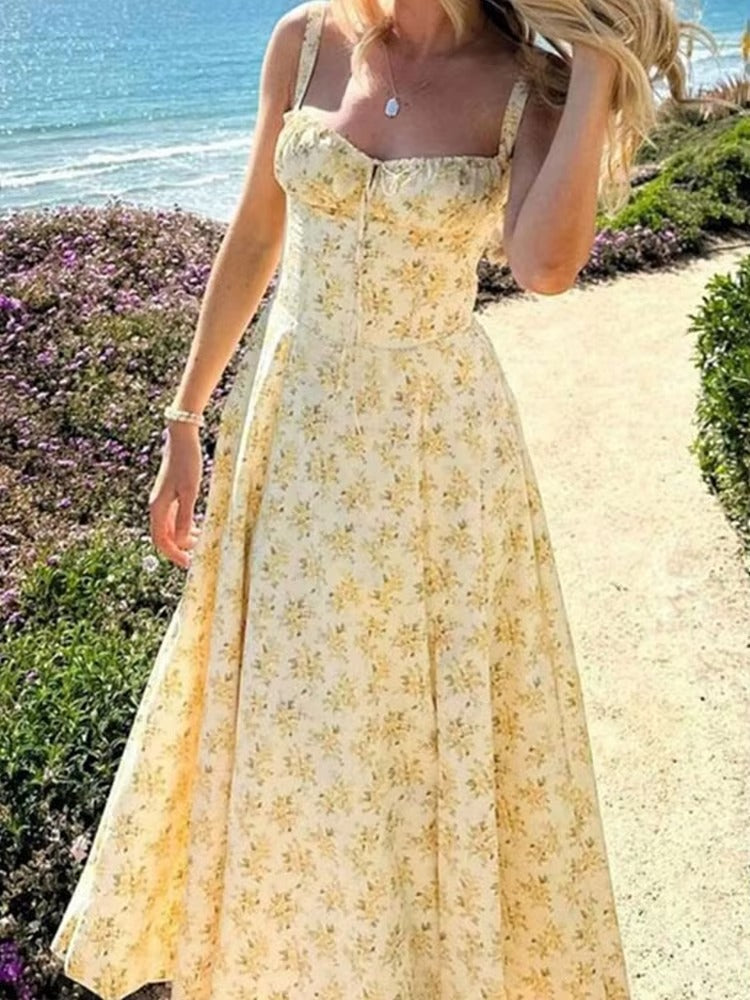 Close-up of a delicate yellow floral pattern on a women's elegant summer midi dress. Soft fabric details.