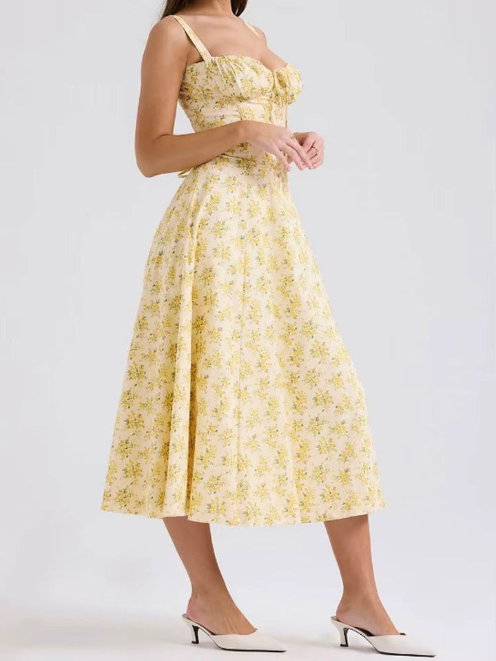 Back view of a women's elegant yellow floral summer midi dress, showcasing its flattering silhouette.