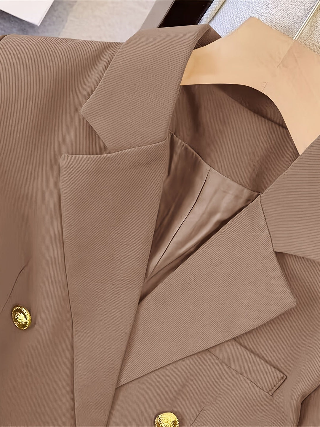 Elegant women's slim blazer with golden buttons, hip-length, long sleeves, in apricot, black, or camel, enhances style.