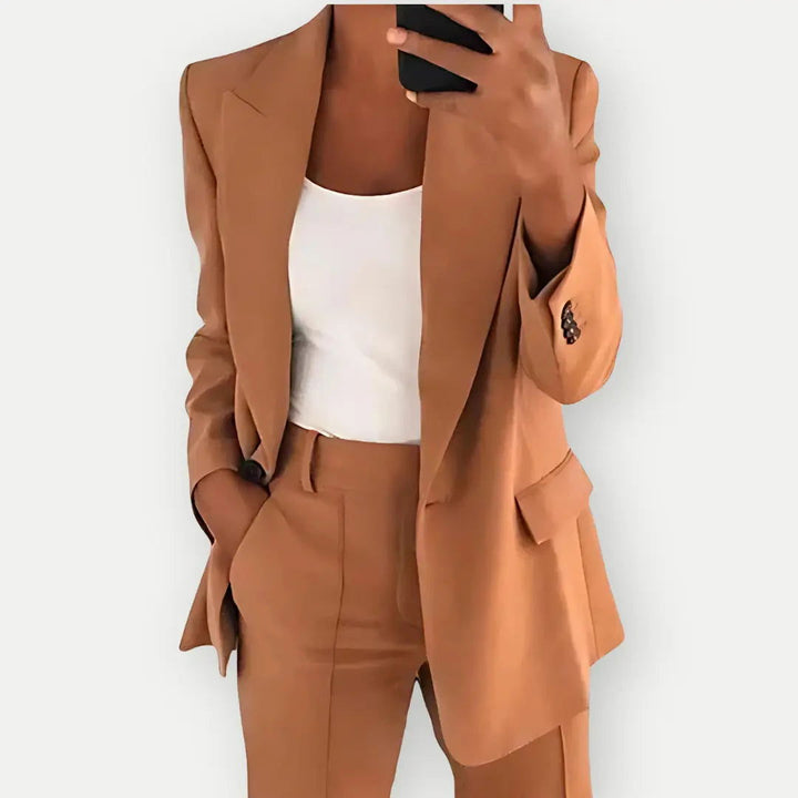 "Elegant women's tailored blazer and trousers set, sleek polyester with sharp lapels, ideal for business and casual wear."