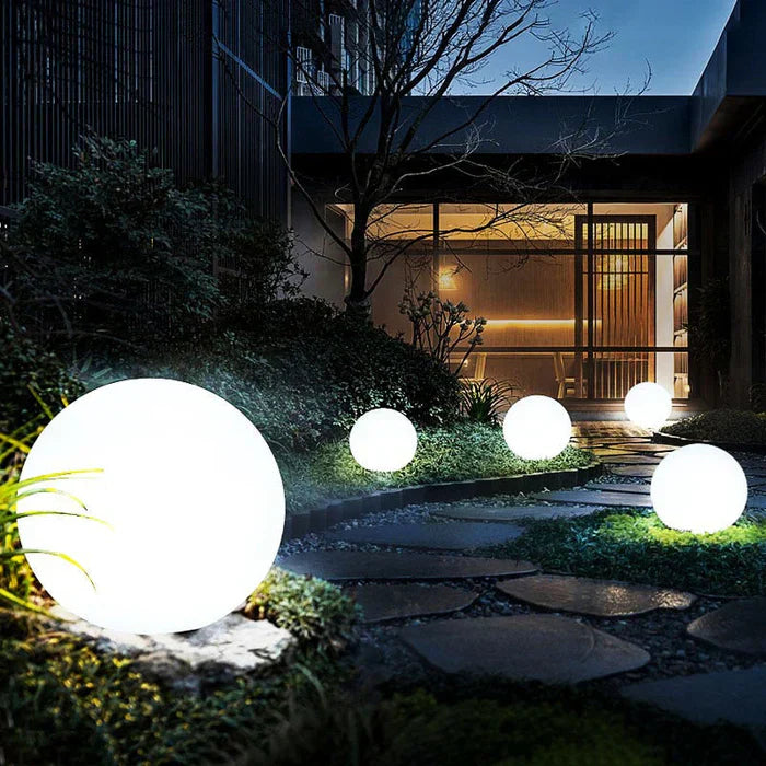 Solar powered spherical garden light, sustainable LED outdoor decor for lawns & pathways.