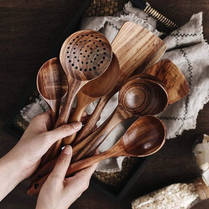 Handcrafted teak wooden cookware set, 7-piece; includes spoons and spatula with unique grain. Perfect for eco-friendly kitche